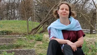 Claudia Mieth sitzt im Garten auf dem Boden