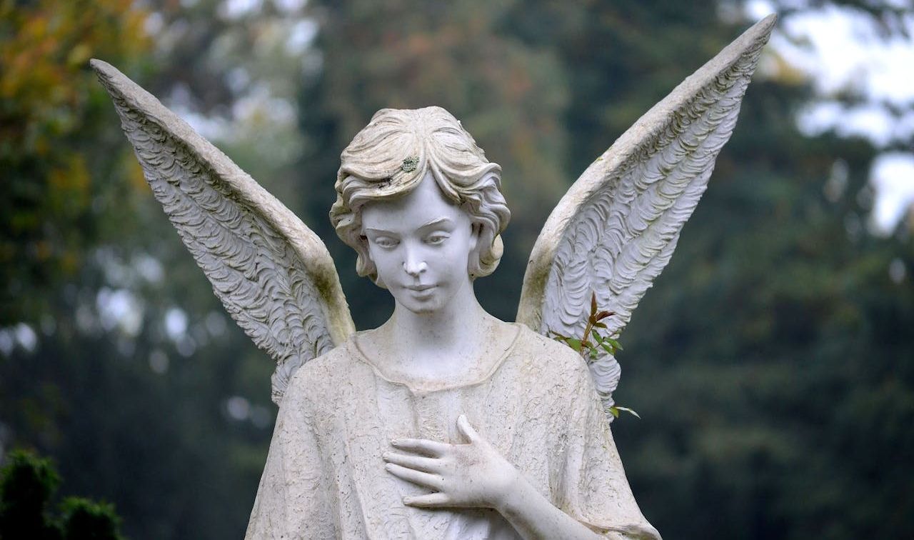 Engelsstatue mit gefalteten Händen und gesenktem Blick