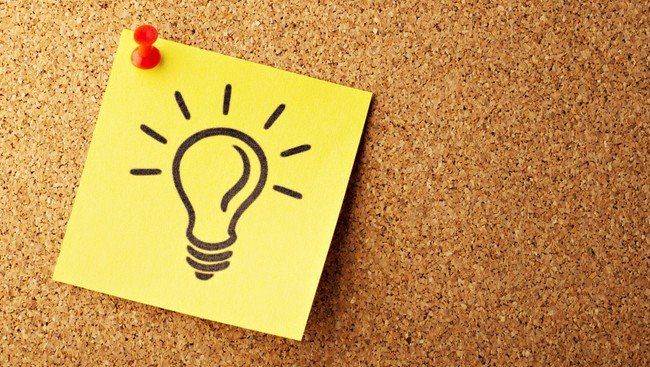 Zettel mit Zeichnung einer Glühbirne auf Pin-Wand