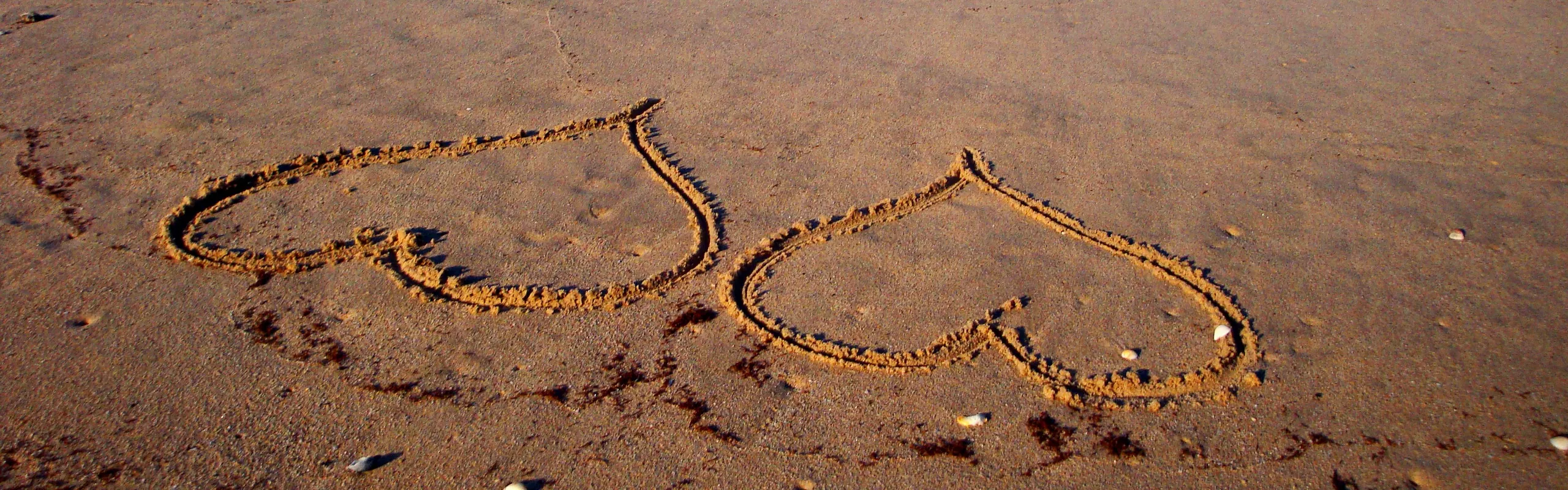 Zwei Herzen in den Sand am Strand gemalt