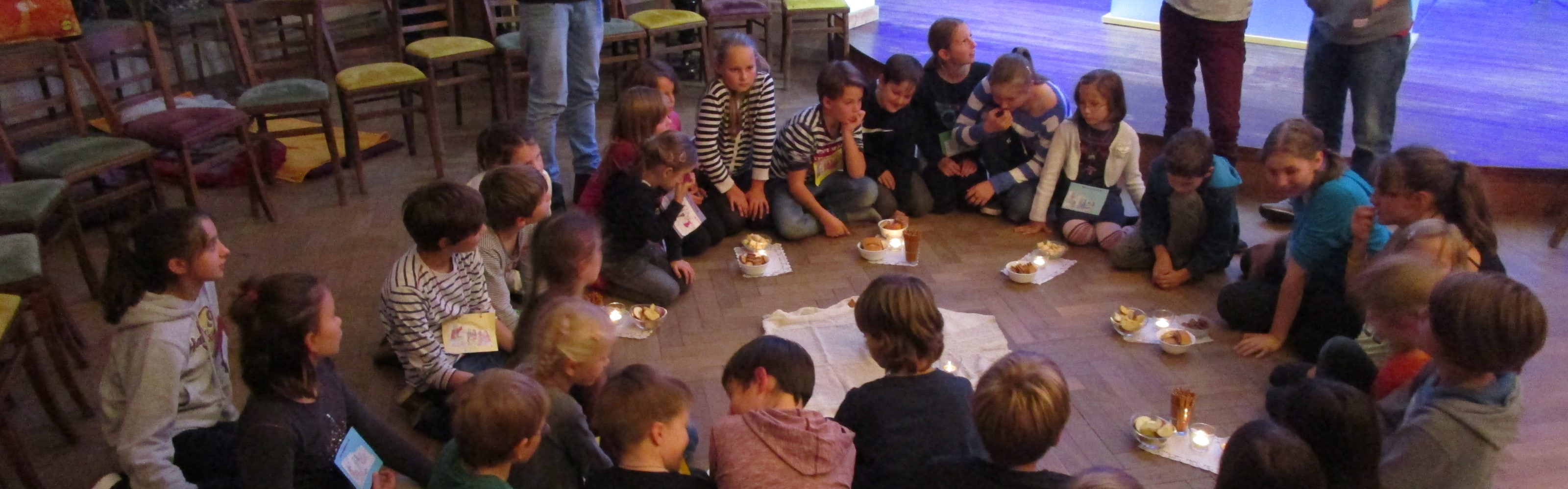 Kinder auf dem Boden im Kreis sitzend