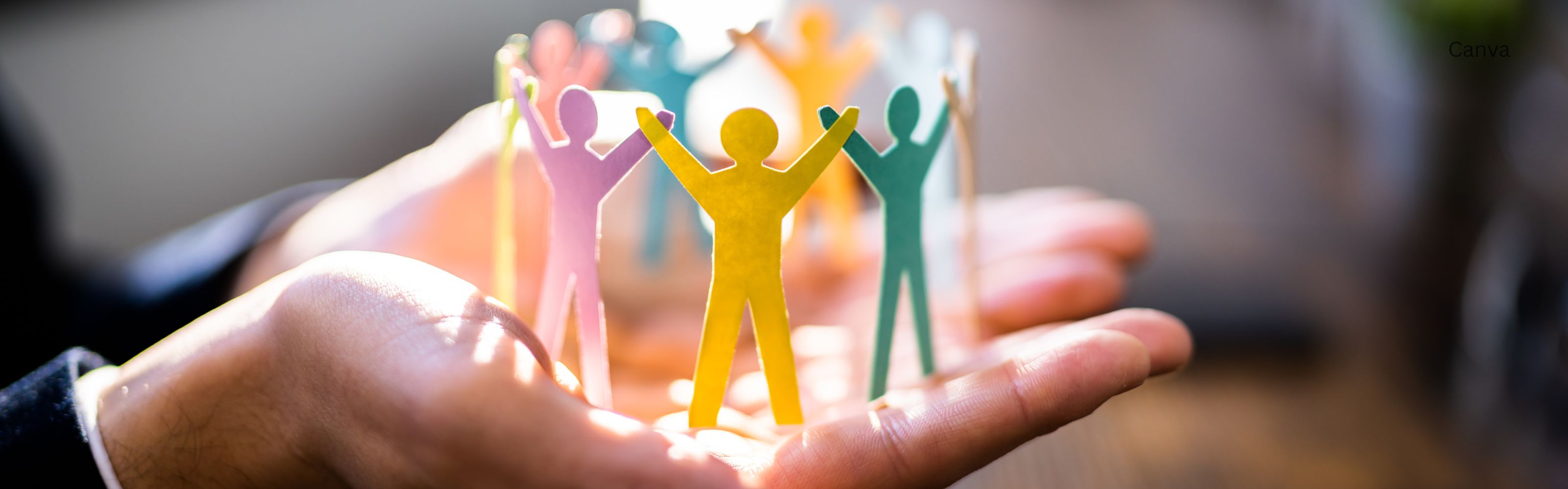 Bunte Papierfiguren stehen Hand in Hand und symbolisieren Gemeinschaft, Vielfalt und Zusammenhalt.