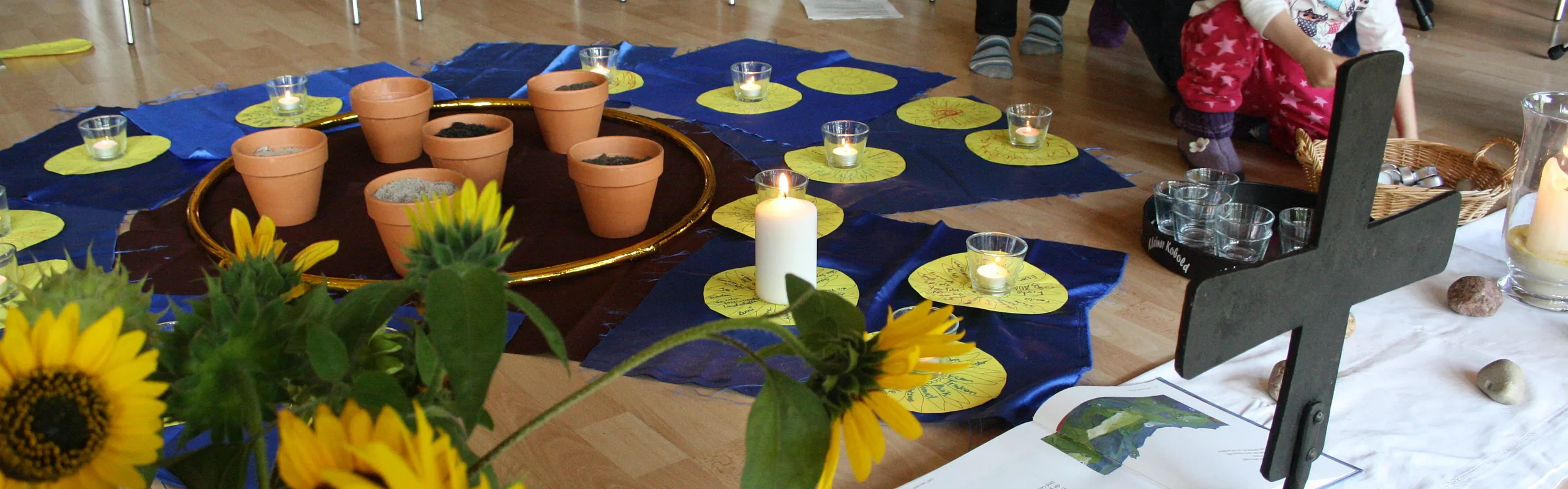 Foto aus der Familienkirche mit Teelichtern und Blumen auf dem Boden